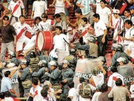 Foto: "La banda enfrentando a los tombos debido a la reprensión policial en el viejo estadio nacional" Barra: La Banda del Basurero • Club: Deportivo Municipal • País: Peru