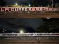 Trapo - Bandeira - Faixa - Telón - "Somos tierra que vence tragedias, arriba y vamos los colombianos" Trapo de la Barra: La Guardia Albi Roja Sur &bull; Club: Independiente Santa Fe &bull; País: Colombia